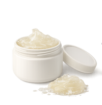 Petroleum jelly with a jar, open lid, and wooden spoon on a white background